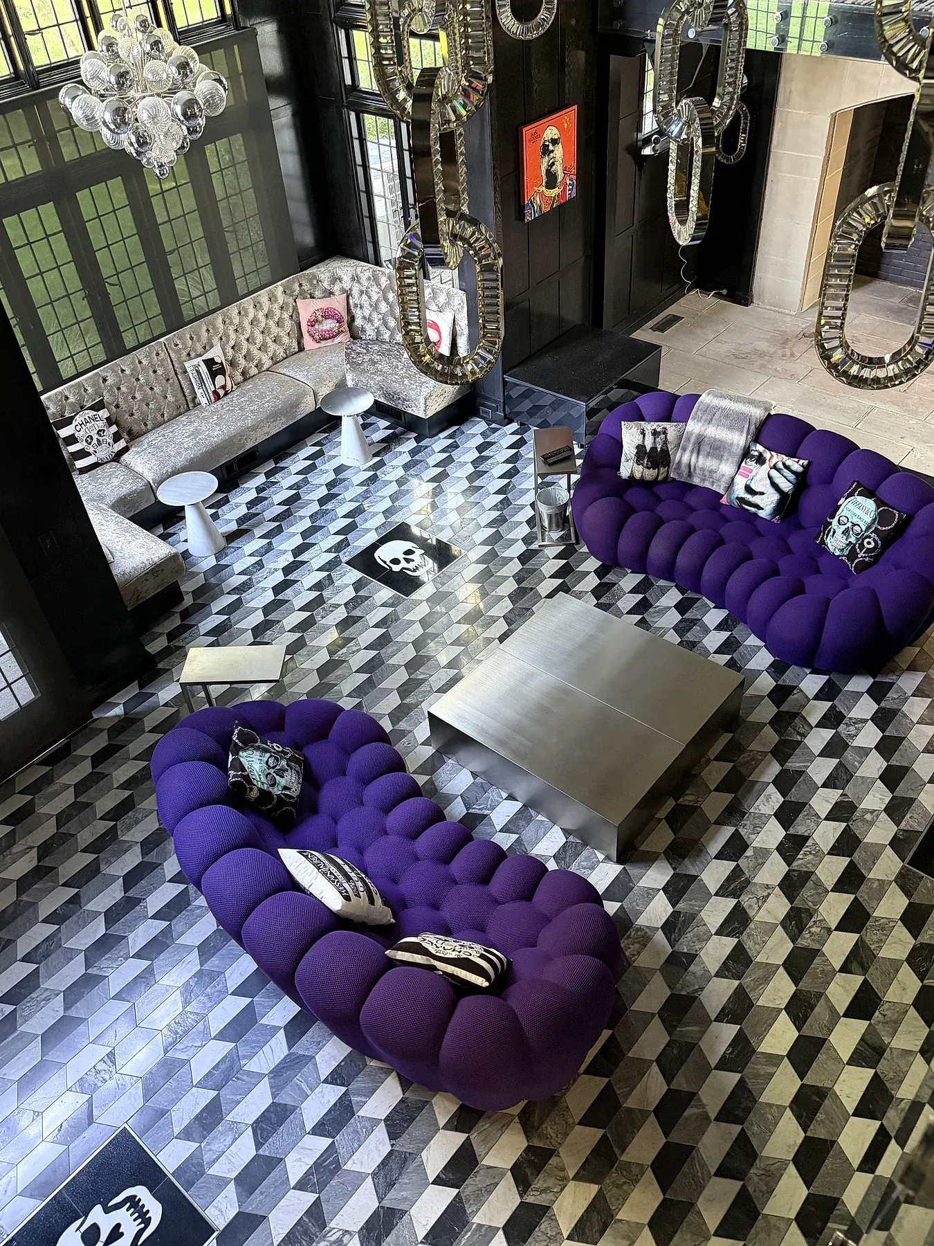 A clean living room with patterned tile flooring and purple upholstered chairs.